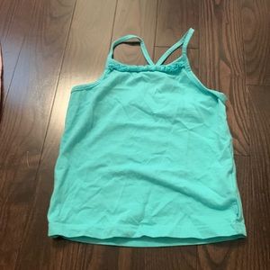 Turquoise tank top crossed straps.